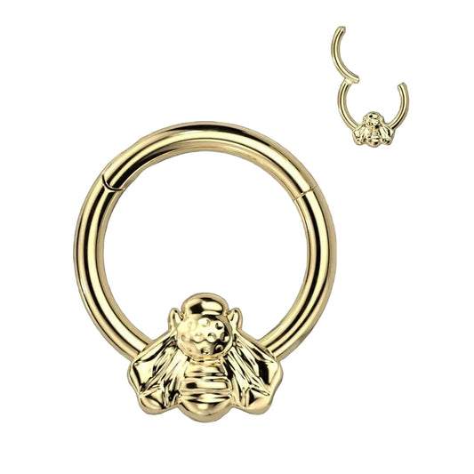 Gold circular earring with a lion head design on a black background